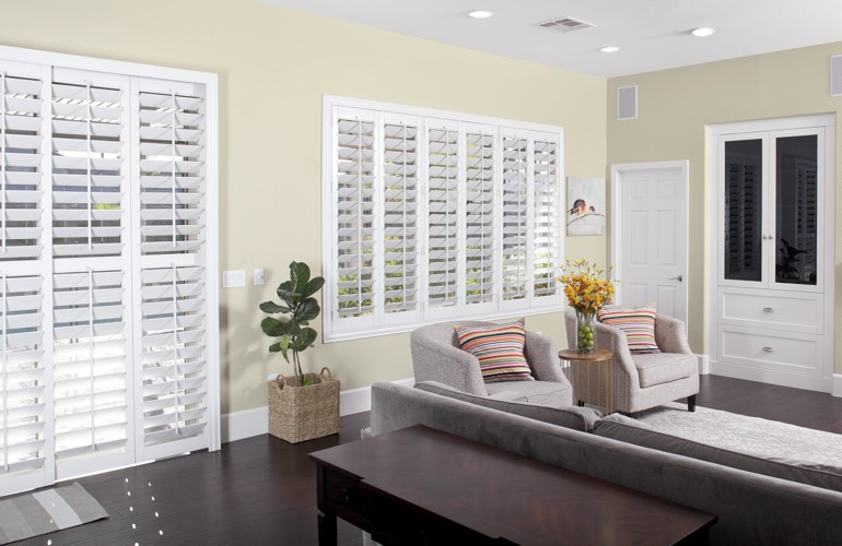 White plantation shutters in living room with dark wood floors